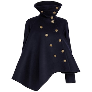 May include: A dark navy blue wool cape featuring a high funnel collar and a double-breasted front closure. The garment is adorned with multiple round, metallic gold-toned buttons arranged in an asymmetrical pattern across the front panel.