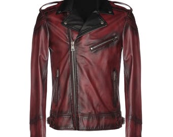 Può includere: Una giacca in pelle con sfumatura rosso scuro e nero, caratterizzata da un ampio colletto dentellato, chiusura asimmetrica con cerniera in metallo color argento, due tasche laterali con zip, una tasca sul petto, spalline e fibbie laterali.