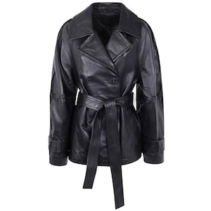 May include: A black leather jacket featuring a double-breasted front with large lapels, long sleeves with buckled cuffs, and a matching tie belt at the waist. The jacket has a smooth finish and visible seams along the sleeves and shoulders.