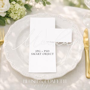 Puede incluir: Un plato blanco con cubiertos dorados, que incluyen un tenedor, un cuchillo y una cuchara, dispuestos para una cena formal. Dos tarjetas blancas se colocan en el plato. La imagen incluye texto que dice "Mockup" y "JPG + PSD SMART OBJECT".