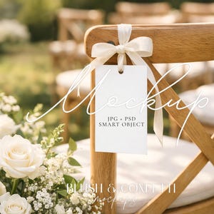 Può includere: Una sedia di legno con un'etichetta bianca legata con un nastro color crema. L'etichetta riporta la scritta "Mockup" e "JPG + PSD SMART OBJECT". Un bouquet di rose bianche e verde è in primo piano.