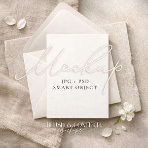 May include: A stationery mockup with a white card and envelope. The word "Mockup" is written in a script font. The card is inside a translucent envelope, on a textured surface. The text "JPG + PSD SMART OBJECT" is also visible. The words "BLUSH & CONFETTI mockups" are at the bottom.
