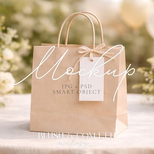 May include: A tan paper gift bag with handles and a white tag tied with a ribbon. The bag has the word "Mockup" written on it in a cursive font. The tag reads "JPG + PSD SMART OBJECT".