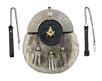 Puede incluir: Un sporran de kilt escocés tradicional con cuerpo de piel, detalles de cuero negro y una parte superior de metal decorativa. El sporran presenta un símbolo masónico y borlas colgantes, con correas y cadenas de cuero.