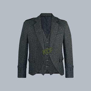 Puede incluir: Un traje de tweed gris con chaleco a juego. El traje tiene un diseño clásico con solapa de muesca, puños abotonados y cierre de tres botones. El chaleco tiene cierre de tres botones. El traje es de color gris medio.