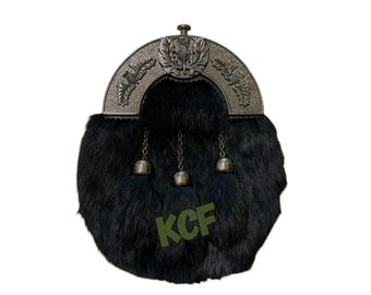 Può includere: Uno sporran di pelliccia nera con un cantle decorativo color argento con un'emblema di cardo. Lo sporran ha tre nappe pendenti e le lettere "KCF" stampate in verde.
