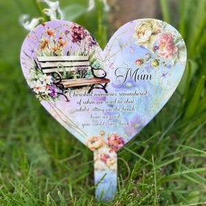 May include: A heart-shaped garden stake with a floral design and the text "Mum Cherished memories remembered. of when we used to chat whilst sitting on the bench. how we wish you could come back"