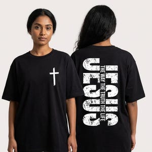 May include: Black t-shirts with white text and graphics. One shirt features a white cross on the front. The other shirt has the word "JESUS" vertically on the back, along with the text "THE WAY THE TRUTH THE LIFE."