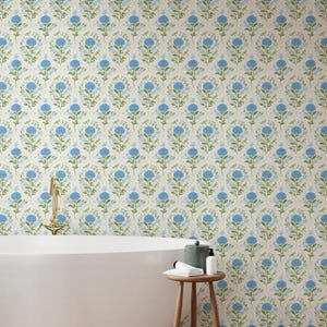 May include: Floral wallpaper featuring a repeating pattern of blue hydrangea blooms and green leaves on a cream background. The wallpaper is visible on a bathroom wall, with a white bathtub and a small wooden stool.