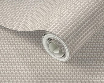 May include: A roll of wallpaper featuring a repeating geometric pattern of small, light beige, oval-shaped indentations arranged in a grid. The texture appears embossed, creating a subtle depth across the surface of the material.