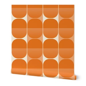 May include: Roll of orange and cream-colored wallpaper with a repeating geometric pattern. The design features rounded rectangles, each divided into two sections with horizontal lines in the lower half. The roll is partially unrolled, revealing the pattern.