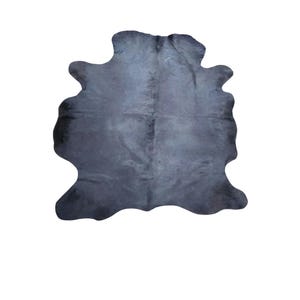 May include: A solid dark charcoal gray cowhide rug with an irregular, organic shape and a smooth, natural texture. The hide features subtle variations in tone across its surface, maintaining a consistent dark color profile throughout the piece.