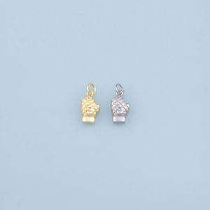 May include: Two small oven mitt charms, one in a gold tone and one in a silver tone. Each charm features a detailed quilted texture and a small circular jump ring at the top for attachment, designed as miniature kitchen accessories.