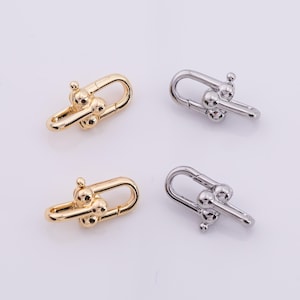 May include: Four metal clasp connectors. Two are gold-colored, and two are silver-colored. Each clasp has a U-shaped design with a small ball at the top and three small balls in the center. The clasps are on a white background.