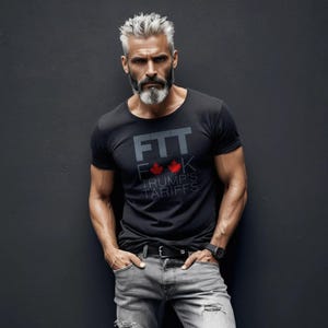 May include: A man wearing a black t-shirt with the text "FTT F**K TRUMP'S TARIFFS" and two red maple leaves. He is wearing grey jeans and a black belt.