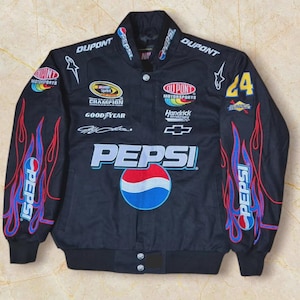May include: Black racing jacket with Pepsi branding and flame graphics on the sleeves. Includes sponsor logos such as DuPont, Champion, and Goodyear. The number 24 is visible on the right sleeve. The jacket has a button-up front.