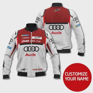 May include: White and red Audi racing jacket with black accents. The jacket features the Audi logo, sponsor logos, and the text "RB LMS Cup." The design includes a zipper closure and a black collar and cuffs. The words "YOUR NAME" are visible.