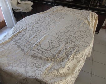 May include: A white tablecloth with a delicate floral pattern. The tablecloth is made of a soft, luxurious fabric and has a subtle sheen.