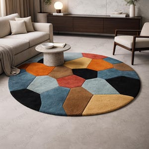 Puede incluir: Una alfombra redonda con un diseño geométrico. La alfombra presenta formas poligonales irregulares en tonos de negro, azul, naranja, marrón y amarillo. Se encuentra sobre un suelo claro, añadiendo un toque moderno a la habitación.