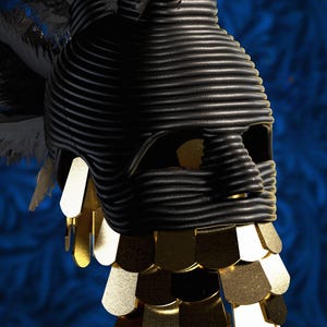 Op de afbeelding: Een zwart hoofddeksel gemaakt van opgerold koord, met een gestructureerde vorm die het bovenste deel van het gezicht en het hoofd bedekt. Het stuk is versierd met een trapsgewijze franje van metallic gouden, schildvormige plaatjes.