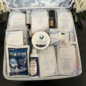 May include: A white rectangular organizer case filled with various personal care items, including a Dove cream jar, Downy wrinkle releaser, instant cold pack, and several labeled pouches containing hygiene, first aid, face, and wardrobe supplies.