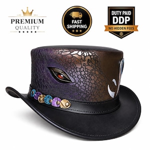 Puede incluir: Un sombrero de copa negro con un patrón de escamas texturizado inspirado en reptiles en tonos morado y bronce. El diseño incluye un ojo estilizado prominente con un iris rojo y una banda adornada con tachuelas decorativas circulares de color metálico.