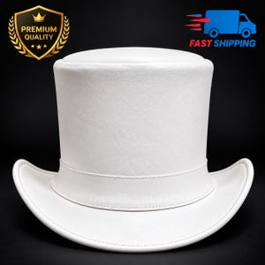 Puede incluir: Un sombrero de copa blanco sólido con una corona estructurada y lisa y un ala curva. El sombrero presenta una banda blanca a juego que rodea la base de la corona. El diseño es limpio y uniforme, mostrando un acabado blanco constante.
