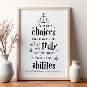 May include: Framed print with a light wood frame. The black text reads "It is our choices that show us what truly we are far more than our abilities." The print includes a triangle, stars, and a wand.