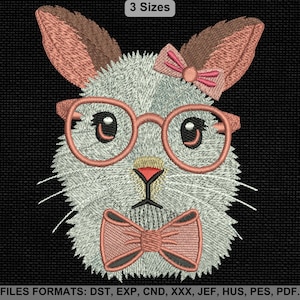 以下が含まれることがあります： メガネ、蝶ネクタイ、リボンが付いたウサギの顔の刺繍デザイン。ウサギは薄いグレーで、耳、メガネ、リボンにピンクのアクセントが付いています。「3 Sizes」という文字が上部にあります。