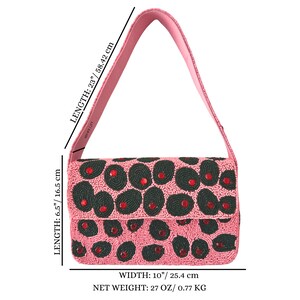 May include: A pink beaded handbag with a matching strap. The bag is 10 inches wide, 6.5 inches high, and 23 inches long. The bag's design features dark green and red accents. The net weight is 27 oz.