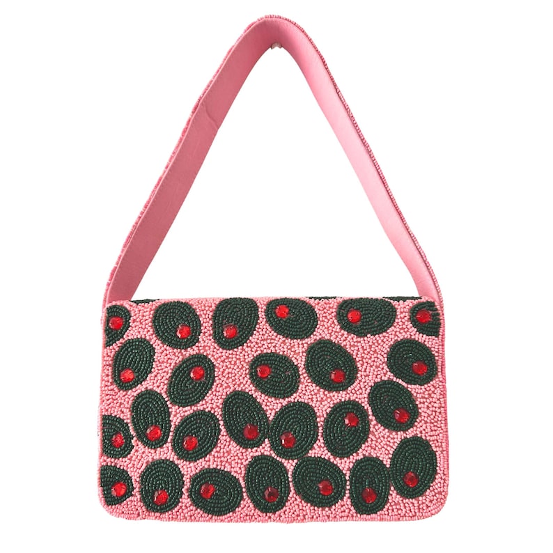 May include: A pink beaded handbag with a matching pink strap. The bag is covered in dark green oval beads with red bead accents, creating a pattern. The bag is rectangular in shape.