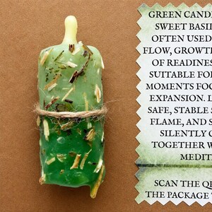 Könnte beinhalten: Eine zylindrische grüne Kerze mit eingearbeiteten getrockneten Kräutern, umwickelt mit einer Schnur. Daneben liegt eine Karte mit dem Text: GREEN CANDLE, SWEET BASIL, OFTEN USED, FLOW, GROWTH, OF READINESS, SUITABLE FOR, MOMENTS FOR, EXPANSION, SAFE, STABLE, FLAME, AND SCAN THE QR.
