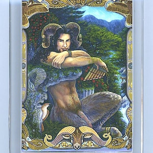 May include: A clear acrylic keychain with a colorful image of a satyr playing a pan flute. The satyr is depicted with brown horns, a human torso, and goat legs. The background features a lush forest scene with a blue sky and mountains.