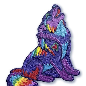 Könnte beinhalten: Ein gestickter Patch mit einem regenbogenfarbenen Wolf, der heult, mit einem Herzen auf der Brust. Der Wolf hat einen Regenbogen-Schwanz.