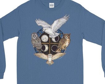 Può includere: Una maglietta blu a maniche lunghe con una grafica di quattro gufi in un cerchio. I gufi sono bianchi, grigi, marroni e bianchi con segni marroni. Il cerchio ha una croce al centro e quattro lune intorno.