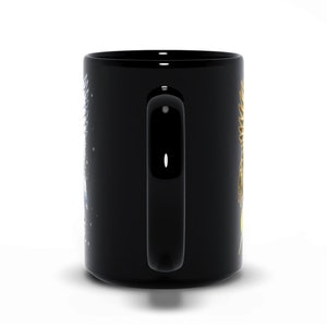 May include: Black ceramic coffee mug with a gold and blue design. The design features a stylized sun and moon with stars.