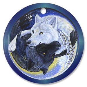May include: A round, blue and white ornament with a yin yang design featuring two wolves, one white and one black, with feathers and stars. The wolves are facing each other and appear to be embracing.
