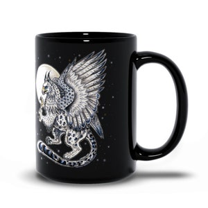 May include: Black ceramic mug with a white griffin with blue accents on a black background with a white moon and stars.