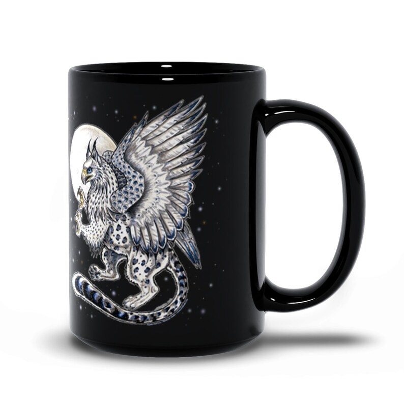 May include: Black ceramic mug with a white griffin with blue accents on a black background with a white moon and stars.