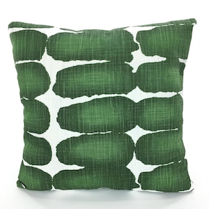 May include: A green and white throw pillow with an abstract pattern of green ovals on a white background.