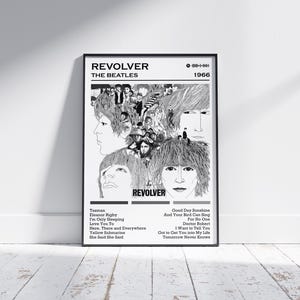 Könnte beinhalten: Schwarz-weiß-Poster des Beatles-Albums "Revolver" von 1966. Das Poster zeigt eine Collage der Gesichter der Bandmitglieder und die Titelliste. Das Poster ist in einem schwarzen Rahmen und an einer weißen Wand ausgestellt.