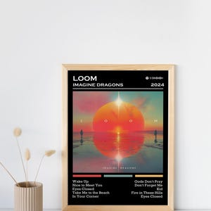 Puede incluir: P&oacute;ster enmarcado con la portada del &aacute;lbum "LOOM" de Imagine Dragons, lanzado en 2024. La obra de arte representa una vibrante escena de atardecer con un gran sol naranja y siluetas de personas. Tambi&eacute;n incluye la lista de canciones del &aacute;lbum.