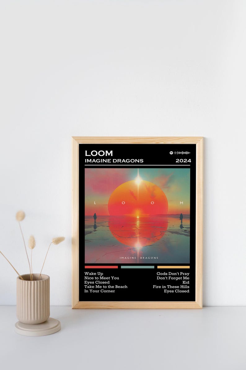 Puede incluir: P&oacute;ster enmarcado con la portada del &aacute;lbum "LOOM" de Imagine Dragons, lanzado en 2024. La obra de arte representa una vibrante escena de atardecer con un gran sol naranja y siluetas de personas. Tambi&eacute;n incluye la lista de canciones del &aacute;lbum.