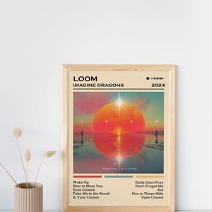 Puede incluir: Un p&oacute;ster enmarcado del &aacute;lbum "LOOM" de Imagine Dragons de 2024. La obra de arte representa una escena de atardecer con un gran sol naranja y dos figuras silueteadas. Los t&iacute;tulos de las canciones est&aacute;n listados debajo.