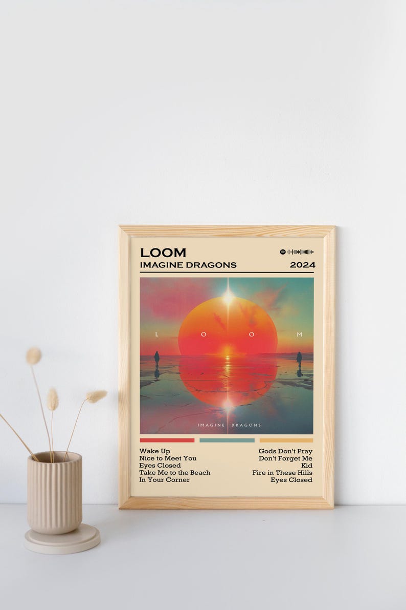 Puede incluir: Un p&oacute;ster enmarcado del &aacute;lbum "LOOM" de Imagine Dragons de 2024. La obra de arte representa una escena de atardecer con un gran sol naranja y dos figuras silueteadas. Los t&iacute;tulos de las canciones est&aacute;n listados debajo.