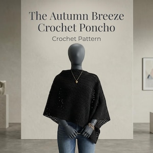 May include: A black crochet poncho worn over blue jeans on a mannequin. The text above reads The Autumn Breeze Crochet Poncho Crochet Pattern. The poncho features a grid-like texture and is paired with a gold-toned necklace and a multi-strand bracelet.