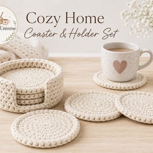 Könnte beinhalten: Ein cremefarbenes Häkel-Untersetzer- und Halter-Set. Das Set enthält einen Halter mit Untersetzern im Inneren und drei zusätzliche Untersetzer. Eine Tasse mit Herzdesign steht auf einem Untersetzer. Der Text "Cozy Home Coaster & Holder Set" ist sichtbar.