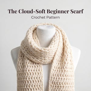 May include: A cream-colored crocheted scarf with a textured, repeating stitch pattern draped over a white mannequin. The text "The Cloud-Soft Beginner Scarf" and "Crochet Pattern" is printed in dark brown letters above the scarf.