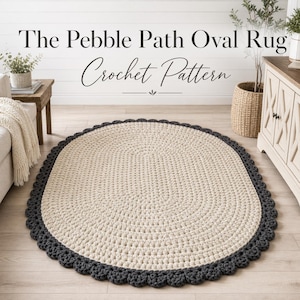 Könnte beinhalten: Ein ovaler Häkelteppich mit cremefarbenem Zentrum und dunkelgrauem, gewelltem Rand. Der Teppich wird auf einem hellen Holzboden präsentiert. Der Text "The Pebble Path Oval Rug Crochet Pattern" befindet sich oben im Bild.
