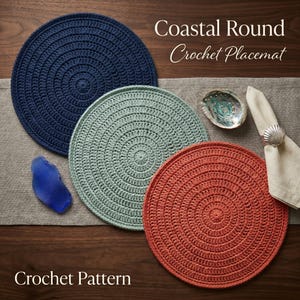 May include: Three round, crocheted placemats in navy blue, seafoam green, and coral. The placemats are arranged on a wooden surface with a gray runner, a seashell, and a napkin with a shell-shaped ring. The text "Coastal Round Crochet Placemat" and "Crochet Pattern" are visible.